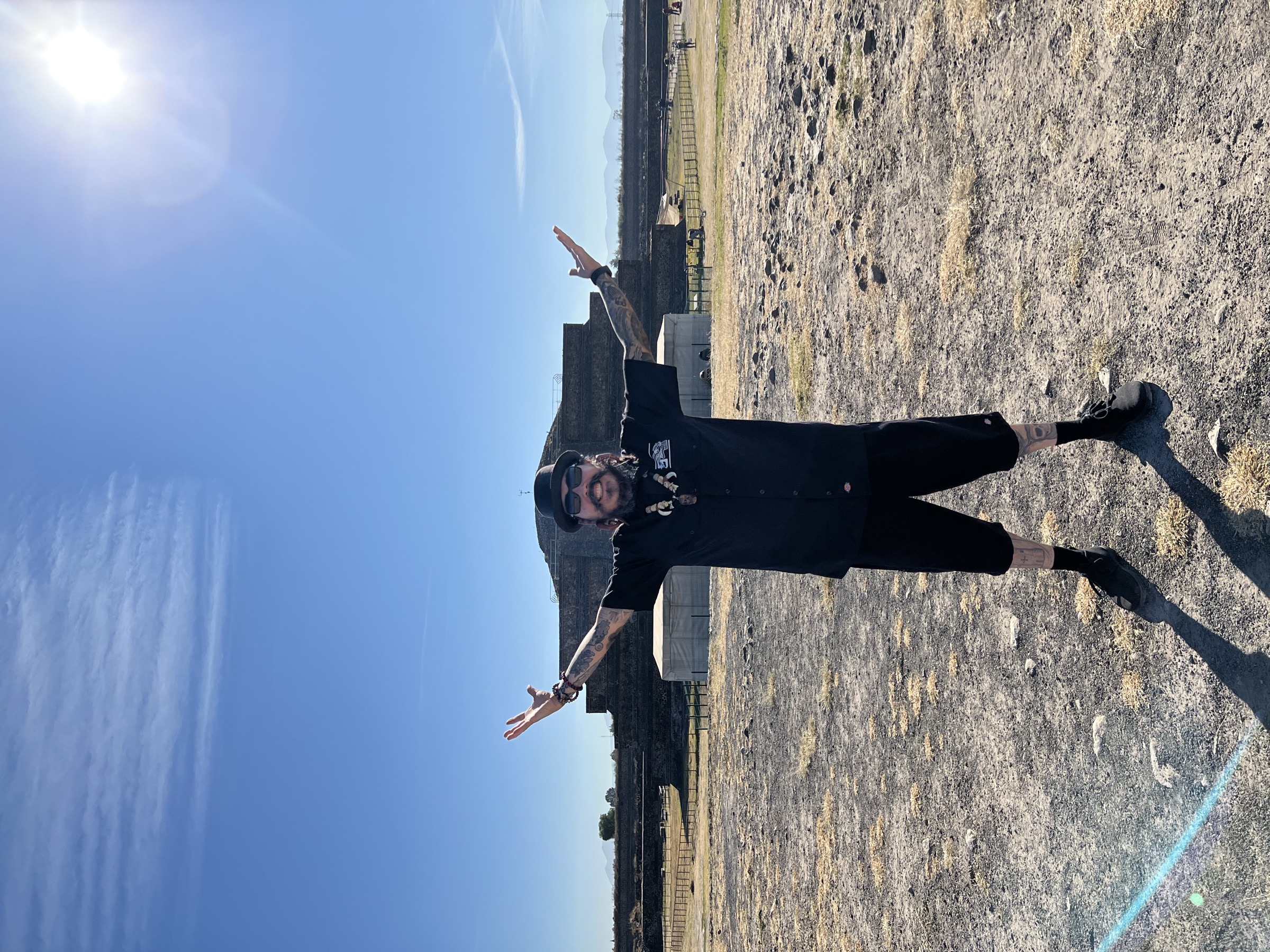 Arms extended at an ancient stone site — reaching down into the ancestral source.