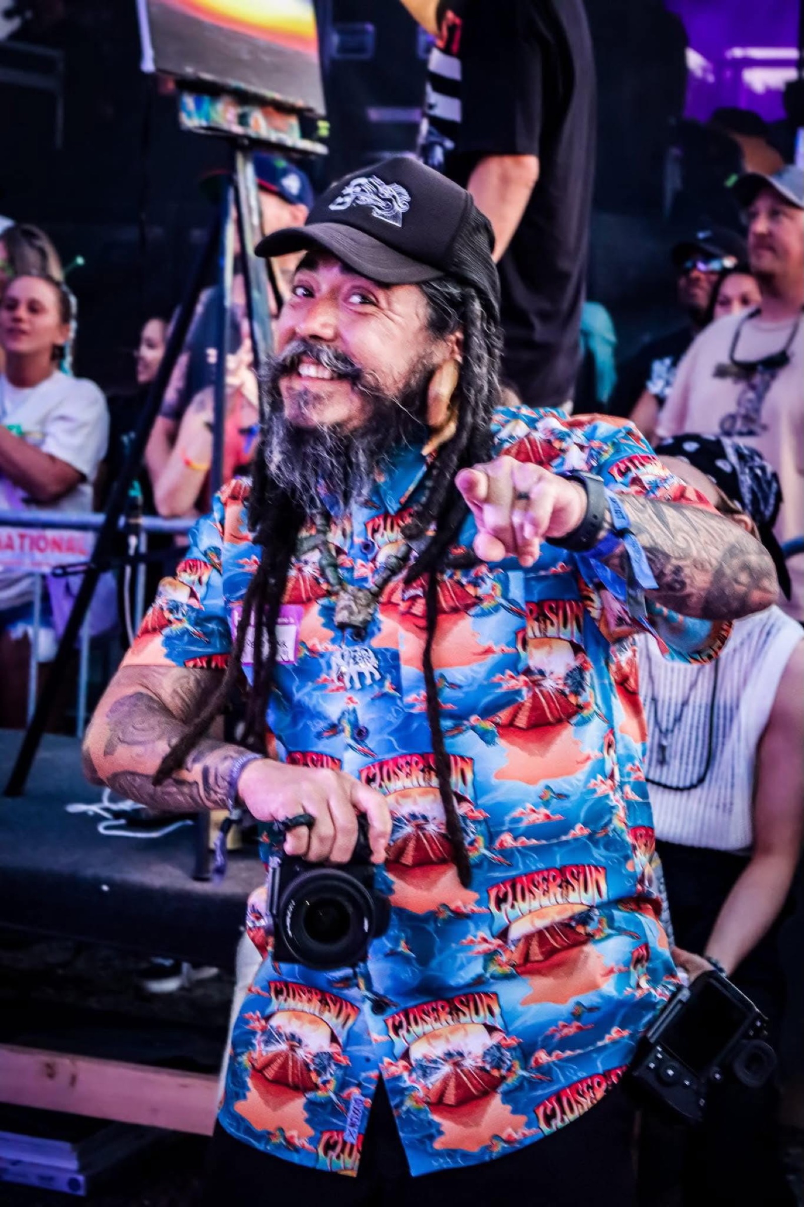 Mid-performance at the festival — pointing beyond the frame, media in motion.